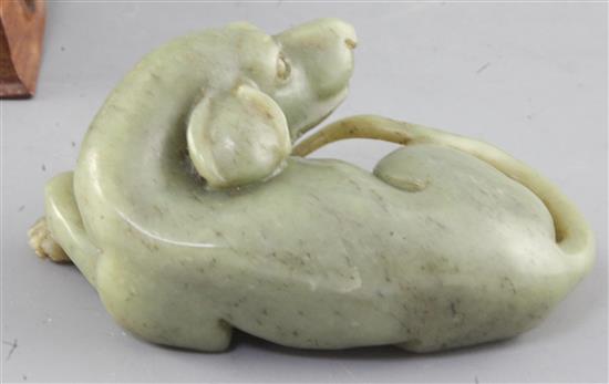 A Chinese green jade figure of a recumbent dog, length 12.5cm excl. wood stand